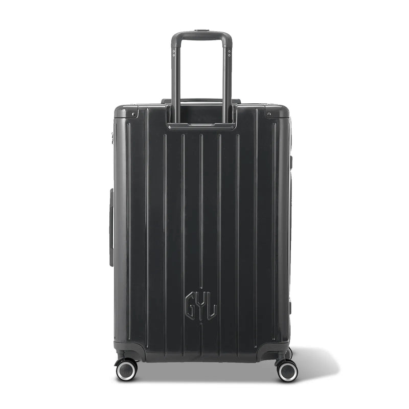 Vue arrière de la valise rigide GYL Intemporelle noir avec poignées intégrées et roulettes pivotantes. #couleur_gris foncé