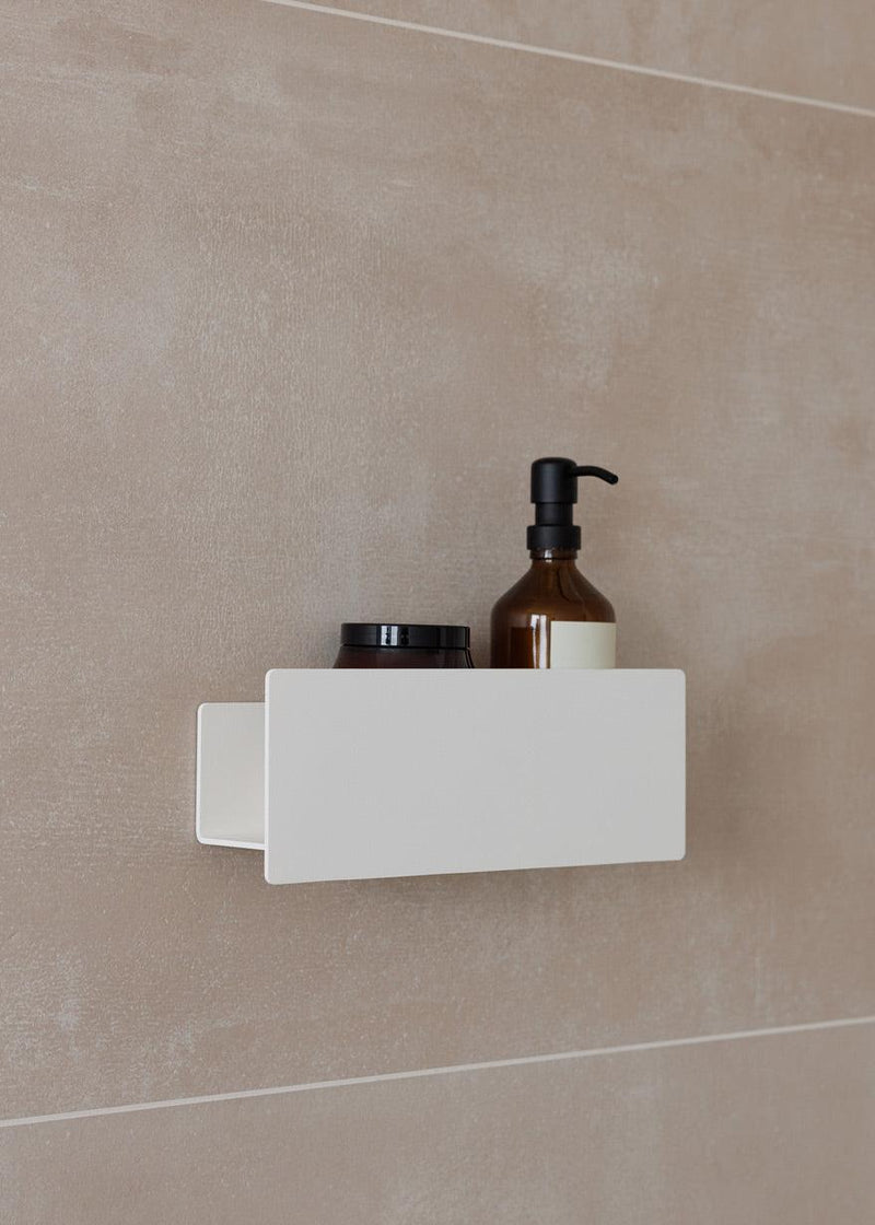 Duschable SHEA an einer Wand mit Pflegeprodukten in der Dusche, schlichtes Design für optima Aufbewahrung.