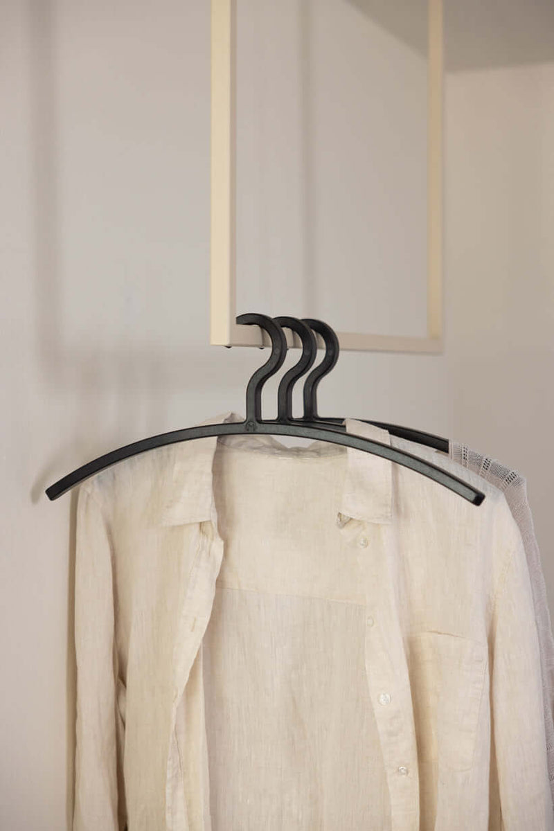 Kleiderbügel FAY im minimalista Design mit beige Bluse im Hintergrund, ideal para tu Schutz empfindlicher Kleidung.
