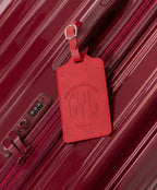 GYL dark red luggage tag attached to Intemporelle dark red suitcase