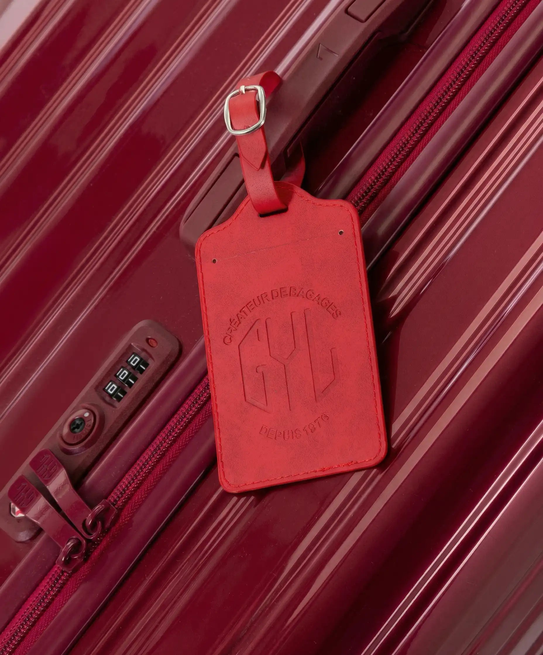 GYL dark red luggage tag attached to Intemporelle dark red suitcase