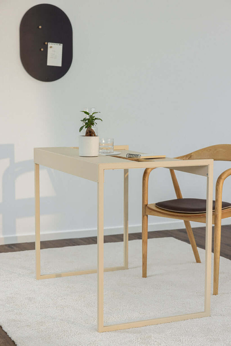 Schreibtisch DONNA in modern Raum mit Stuhl, Pflanze und Schreibmaterial.