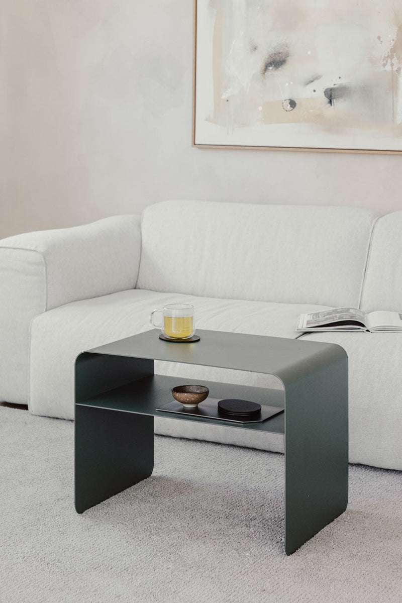 Beistelltisch COSMO aus pulverbeschichtetem Metall, moderno y minimalista, neben einem Sofa platziert.