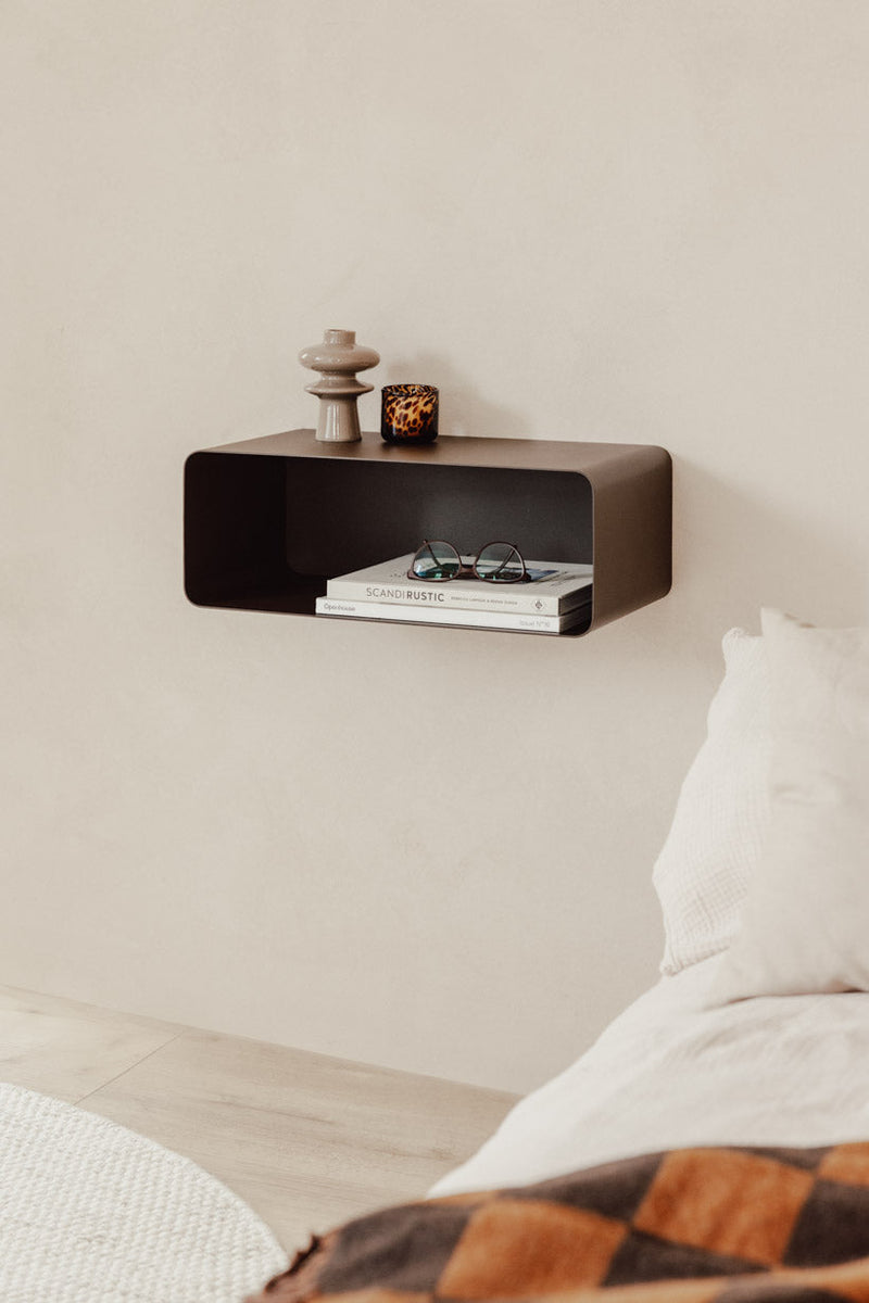 Hängender Nachttisch NELIO an einer Wand mit Dekoration und Bücher auf einer minimalistischen Oberfläche.