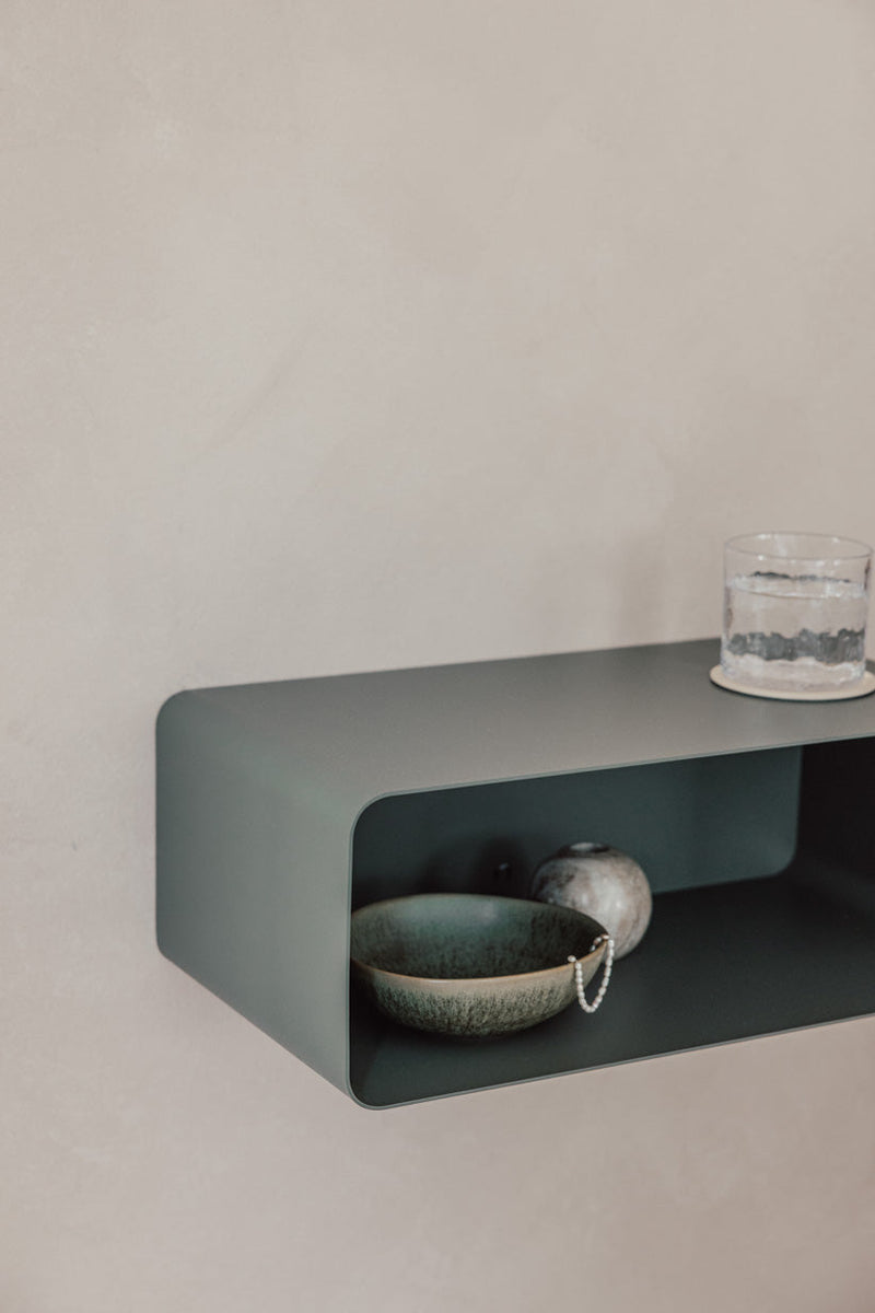 Hängender Nachttisch NELIO in modernm Design mit dekorativen Objekten auf der Ablage.