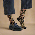 Calcetines KLUE de leopardo en tonos ámbar, respetuosos con el medioambiente, combinados con vaqueros y zapatos de piel negros