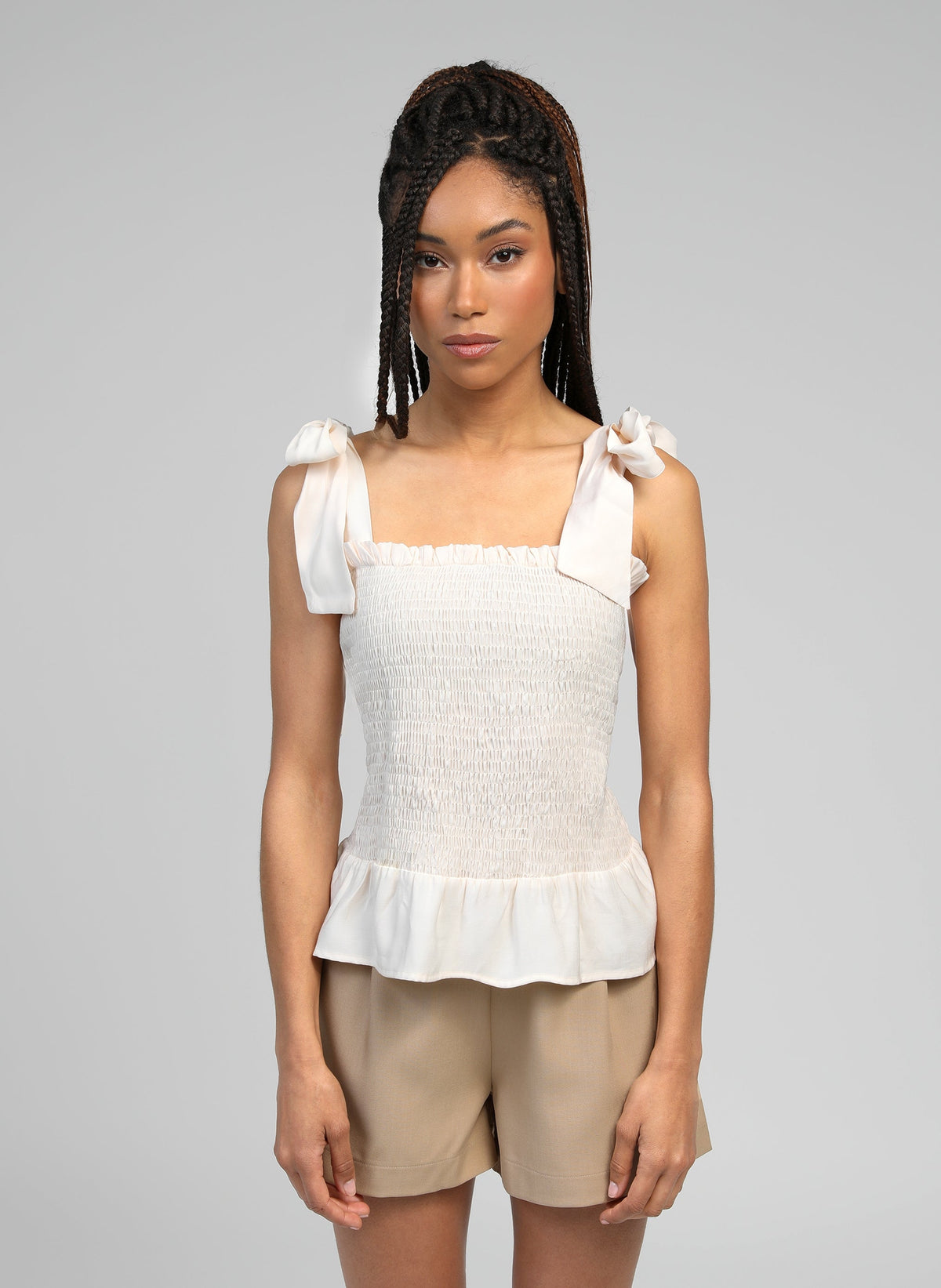 An'ge – Debardeur Korelita Ecru, mannequin portant un top blanc smocké et un short beige