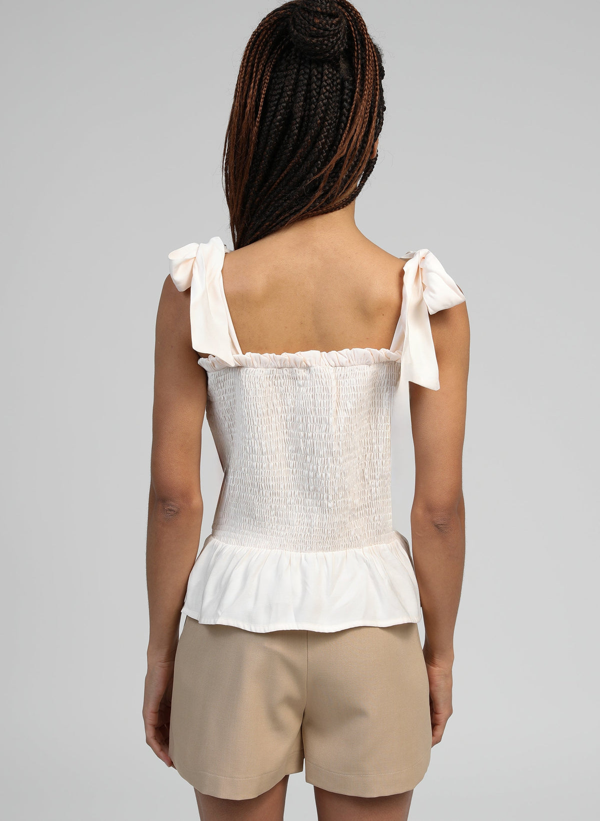 An'ge – Debardeur Korelita Ecru, haut blanc smocké et short beige portés par un mannequin de dos