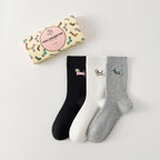 Pack de 3 calcetines altos de canalé. Colores negro, gris jaspeado, blanco. Pequeño perro bordado en la parte exterior del pie. 