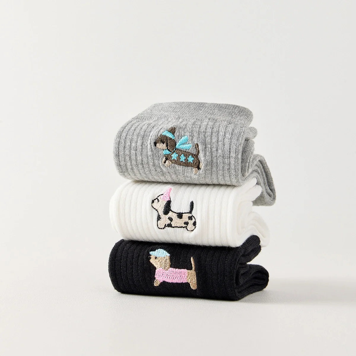 Pack de 3 calcetines altos de canalé. Colores negro, gris jaspeado, blanco. Pequeño perro bordado en la parte exterior del pie. 
