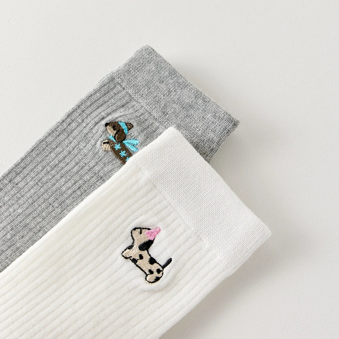 Pack de 3 calcetines altos de canalé. Colores negro, gris jaspeado, blanco. Pequeño perro bordado en la parte exterior del pie. 