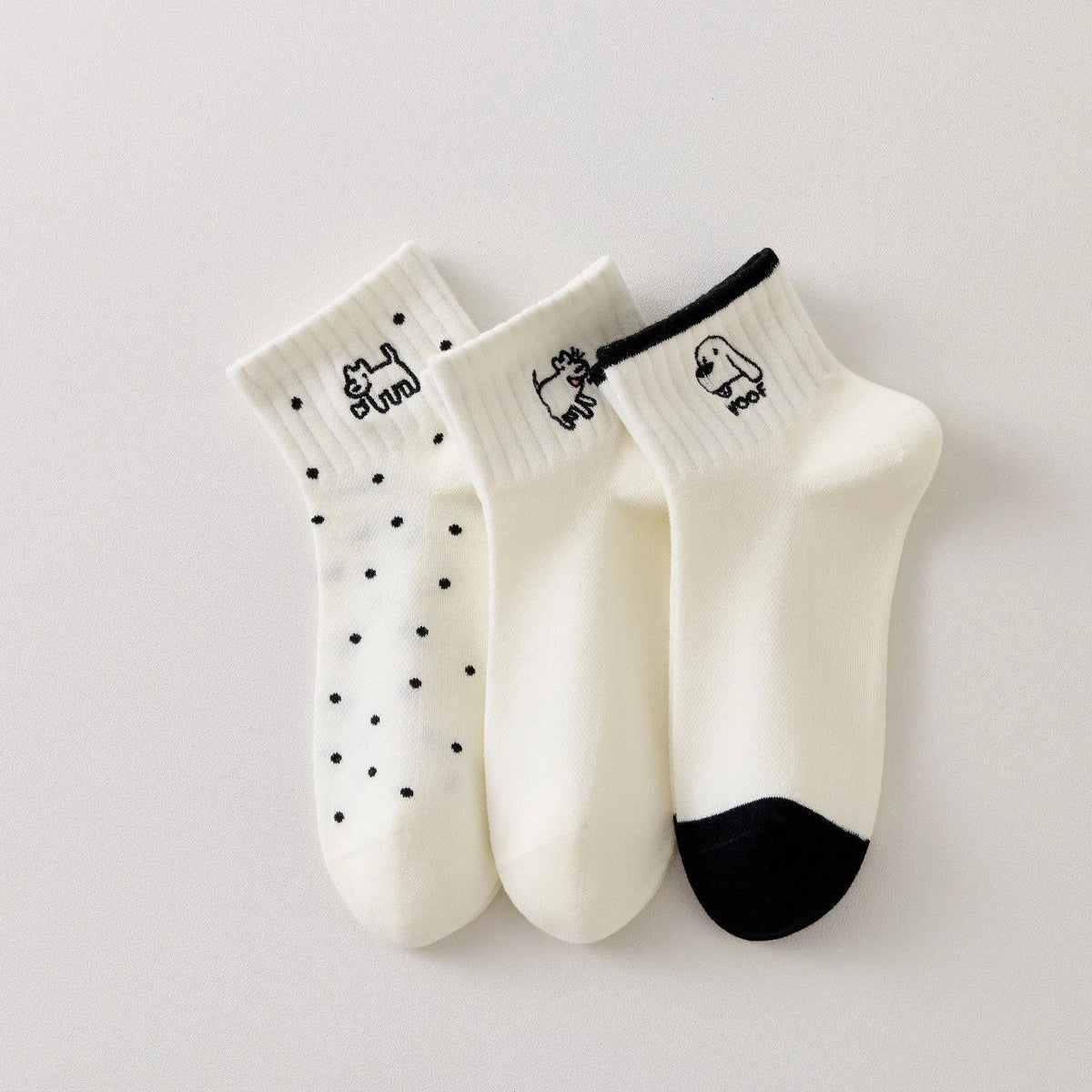 Lot de 3 chaussettes femme noir et blanc avec broderies chien. Motifs graphiques, maille douce et taille 35-41. Style original et confort assuré.