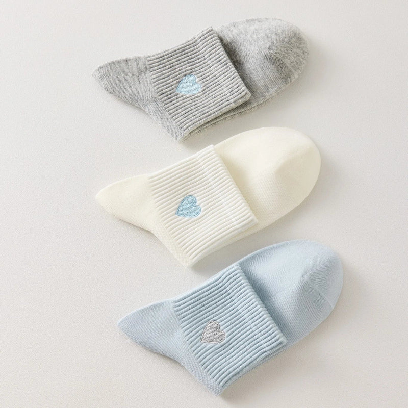 Lot de 3 chaussettes mi-hautes femme avec cœur bleu brodé. Coloris doux : gris, blanc cassé, bleu ciel. Bord côtelé. Confort et style au quotidien.