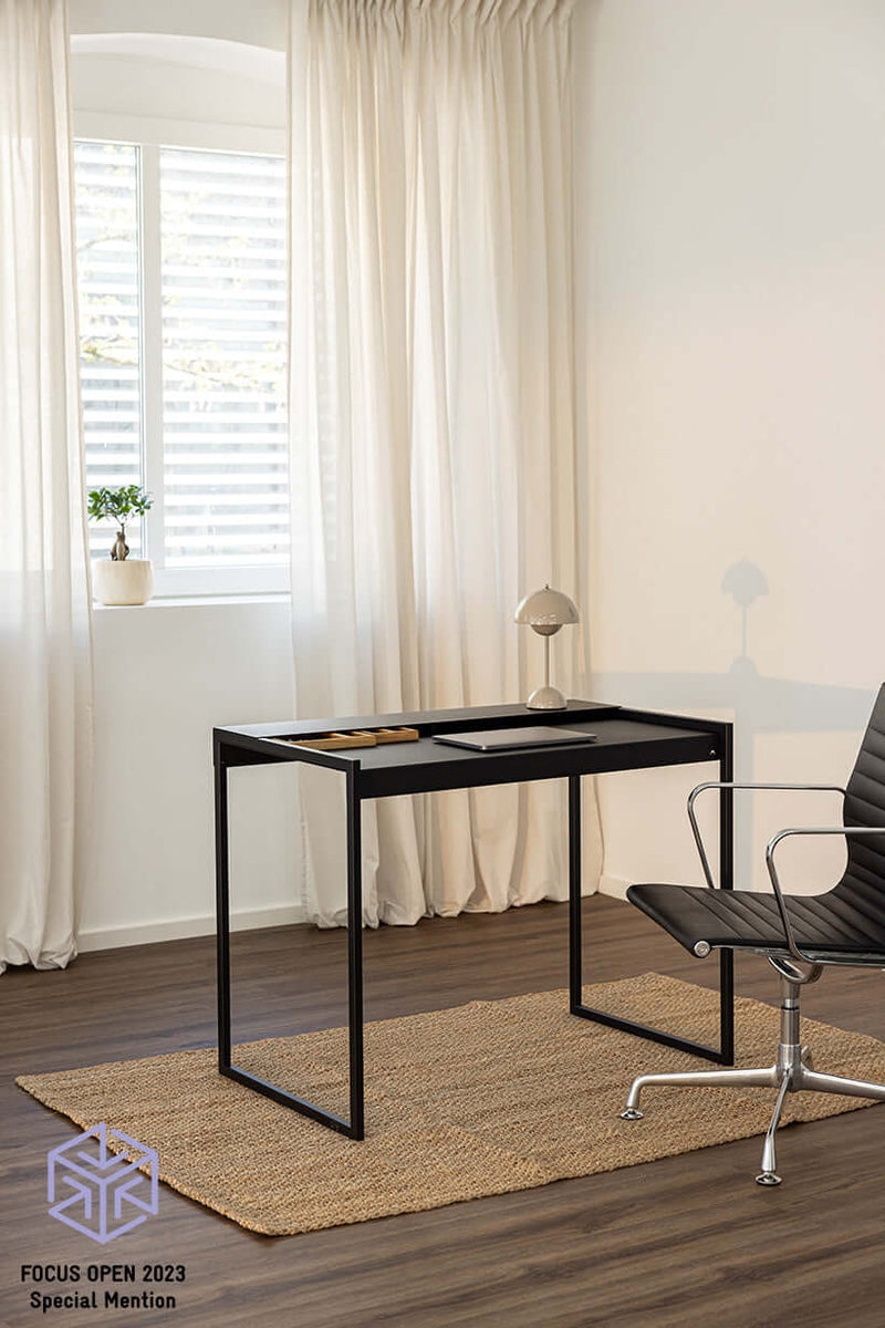 Schreibtisch DONNA in modern Raum mit Stuhl und Teppich, minimalist Design in Schwarz.