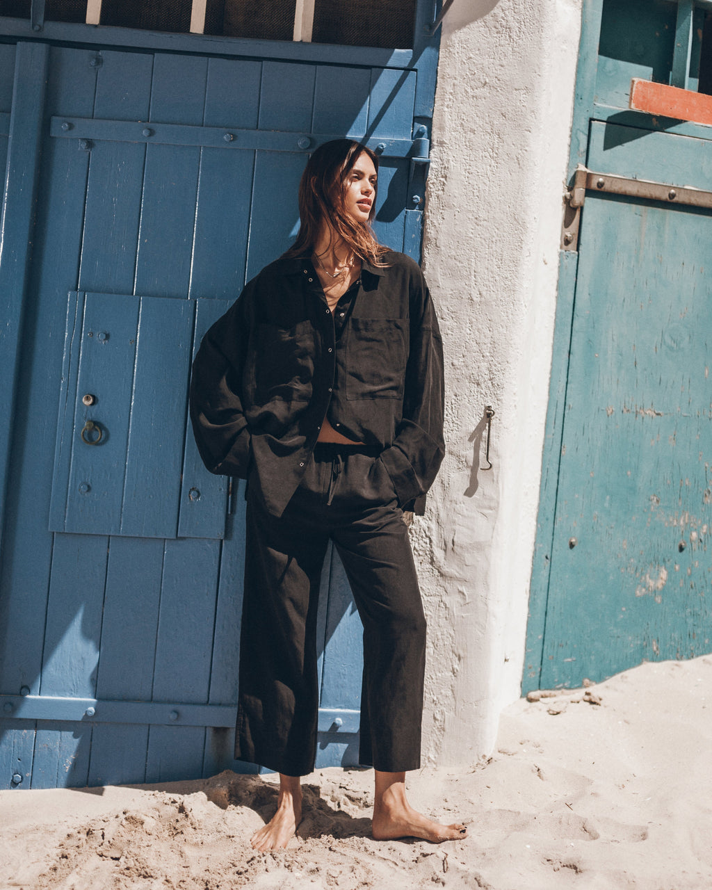 Woman wearing a black button-up shirt and black pants