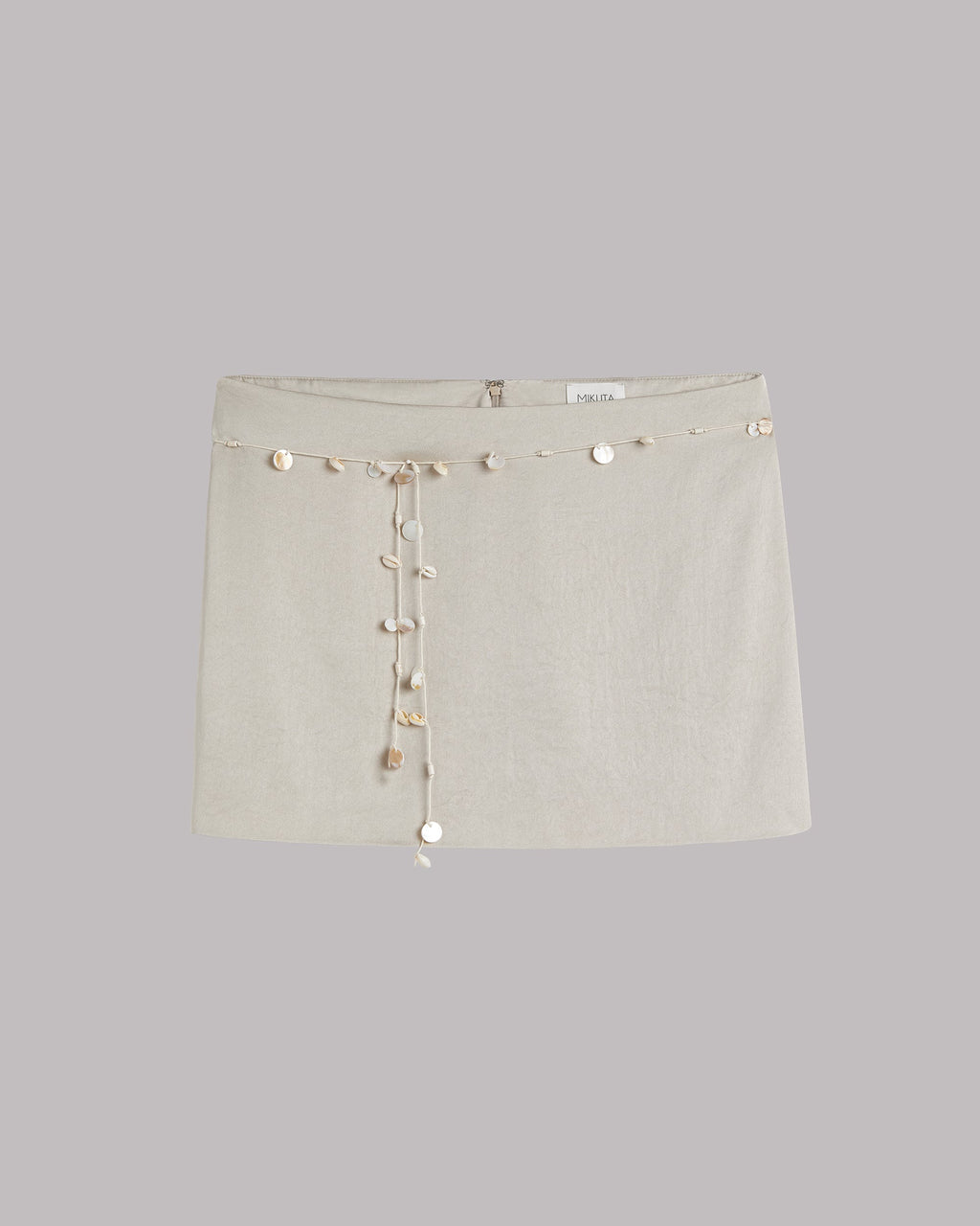 Light mini skirt with decorative shells on a light gray background