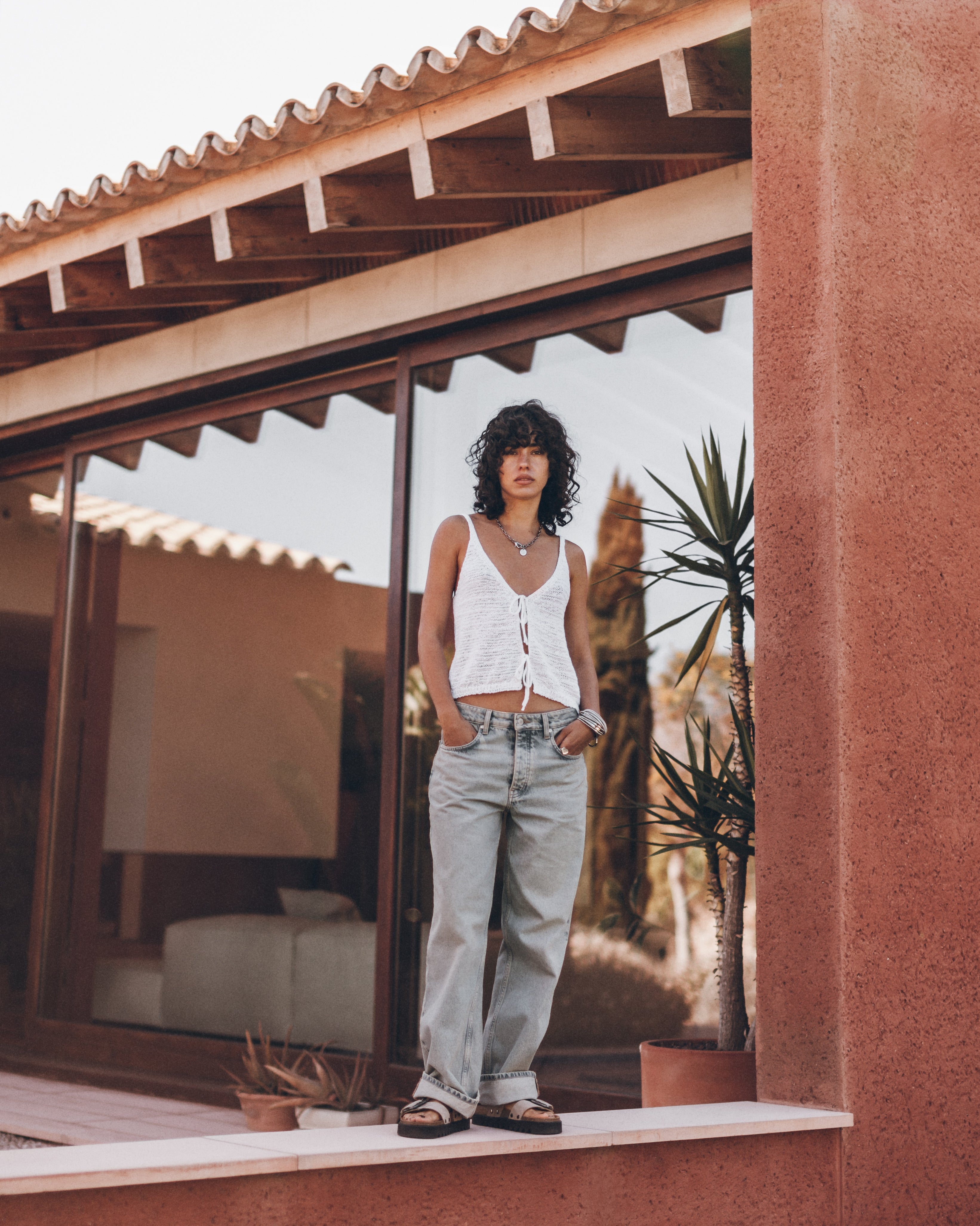 Woman standing in front of a modern house with a reflective surface