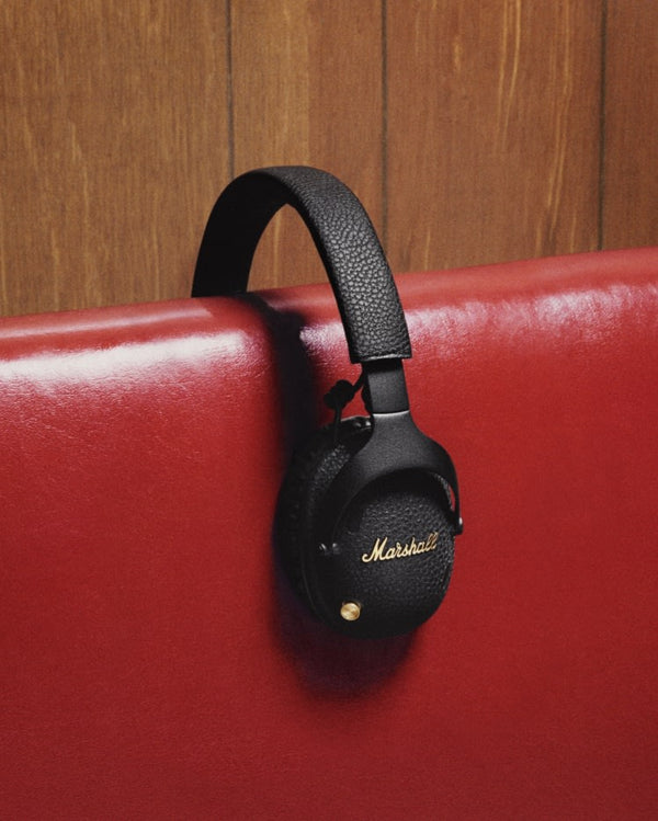 Marshall – Monitor III ANC - Wireless Headphones - Black, black headphones resting on the back of a red sofa
