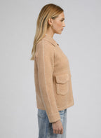 An'ge – Gilet Niba Beige, mannequin de profil portant une veste beige en laine avec des surpiqûres blanches