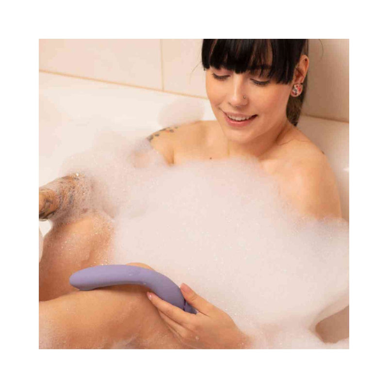 Modèle dans son bain qui tient le vibromasseur point G de Womanizer