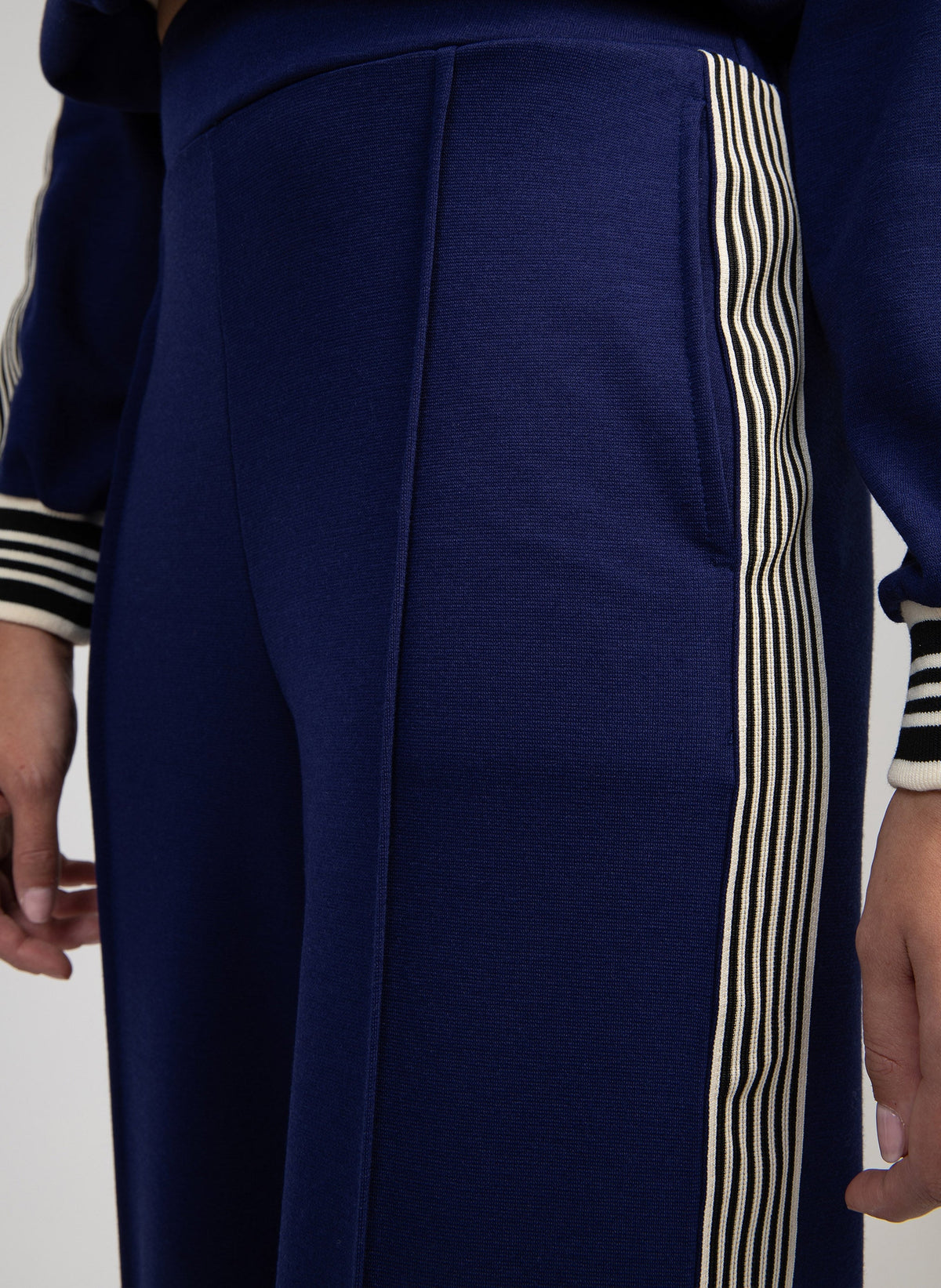 An'ge – Hose Patrivy Blau, marineblaue Jogginghose mit gestreiftem Seitenstreifen, von einem Model getragen