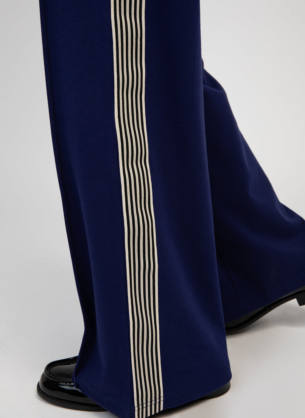 An'ge – Hose Patrivy Blau, marineblaue Hose mit gestreiftem Seitenstreifen, getragen mit schwarzen Slippern