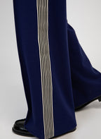 An'ge – Hose Patrivy Blau, marineblaue Hose mit gestreiftem Seitenstreifen, getragen mit schwarzen Slippern