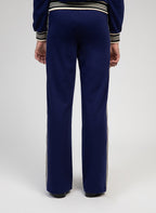 An'ge – Hose Patrivy Blau, marineblaue Jogginghose mit Seitenstreifen, von einem Model von hinten getragen