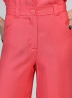 An'ge – Pantalon Phoebila Corail, pantalon corail porté par un mannequin, vue de face, avec poches et bouton