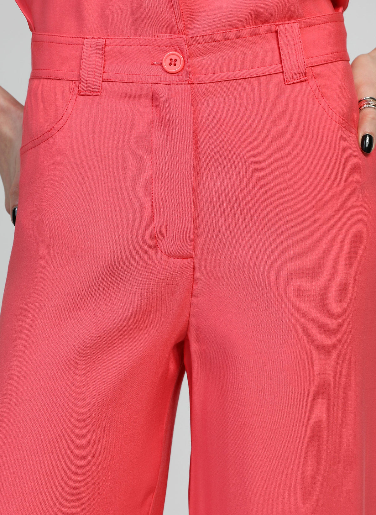 An'ge – Pantalon Phoebila Corail, pantalon corail porté par un mannequin, vue de face, avec poches et bouton