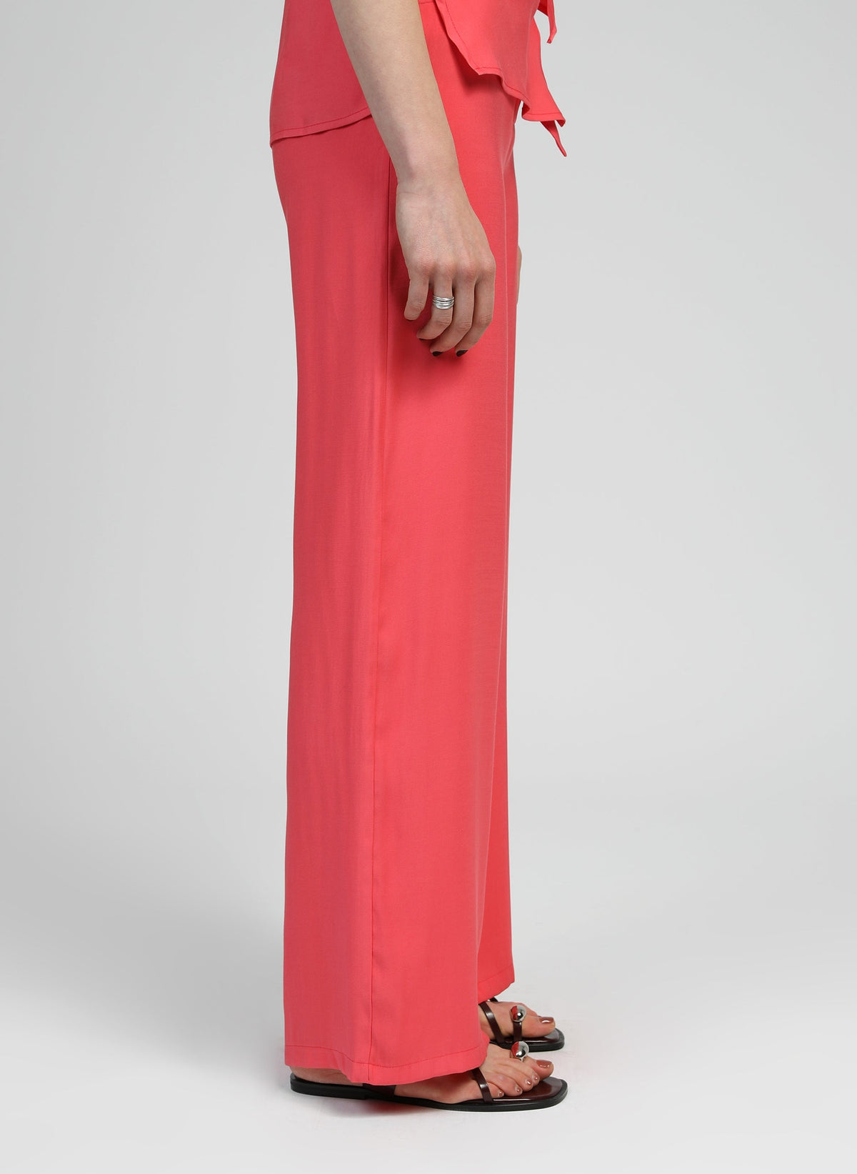 An'ge – Pantalon Phoebila Corail, pantalon large corail porté par un mannequin, vue de profil