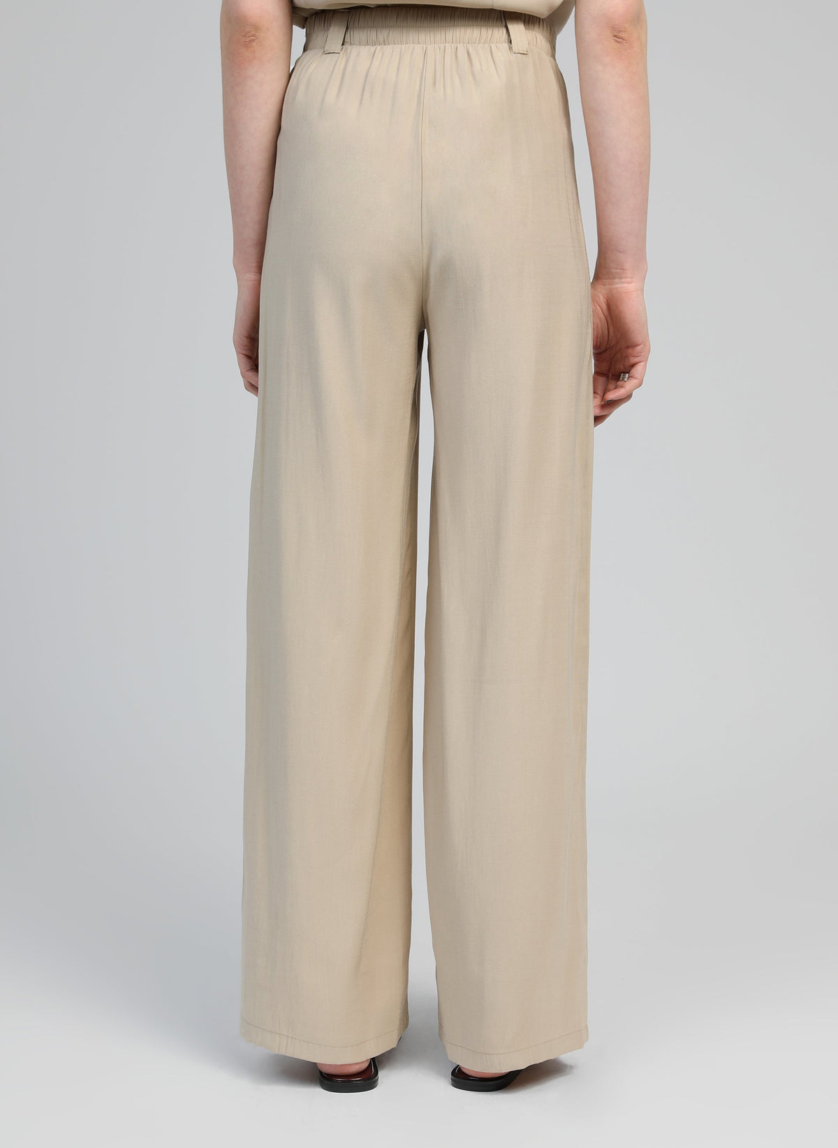 An'ge – Pantalon Phoebila Beige, pantalon large beige clair porté de dos par un mannequin