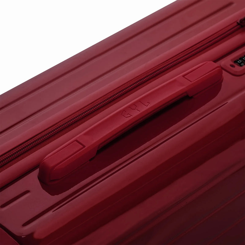 Poignée supérieure rigide de la valise GYL Intemporelle orange avec logo embossé sur le dessus. #couleur_rouge foncé