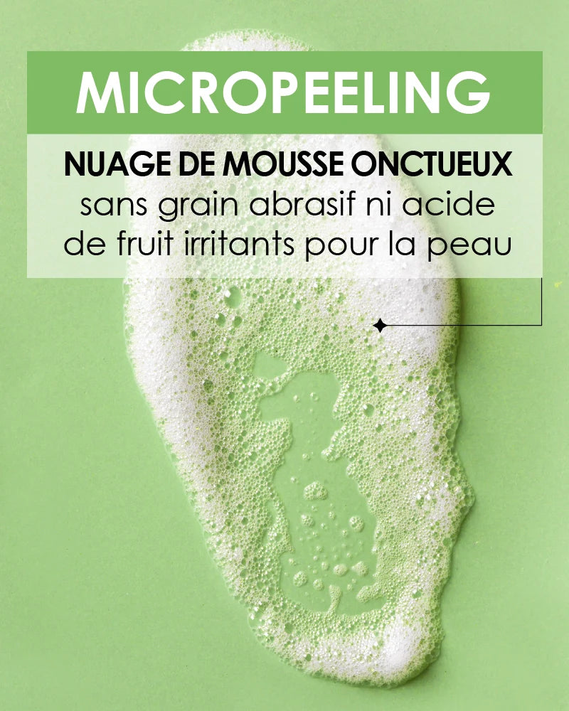 Close-up on the texture of Pschitt Magique Garancia: a cloud of creamy white foam on a green background, with text specifying a formula without abrasive grain or irritating fruit acid.