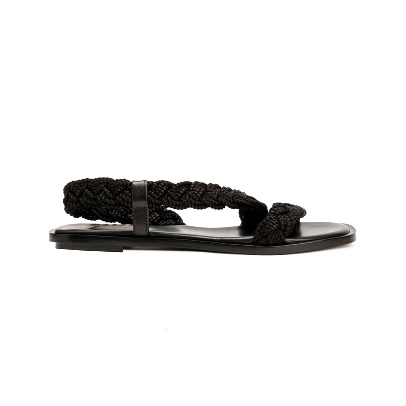 Ronda Black Flat Asymmetric Sandal with braided straps and sleek leather sole, perfect for summer outfits.