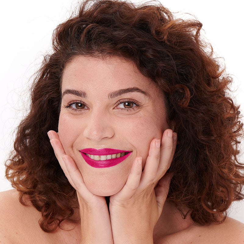 Tono fucsia del lápiz labial Pomponne natural y limpio sobre piel oscura