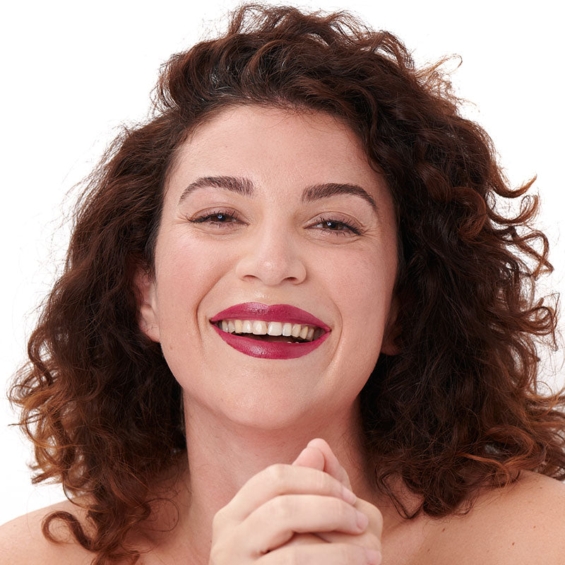 Tono granate de la barra de labios natural y limpia Pomponne en pieles oscuras.