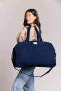Grande borsa da viaggio Yves blu navy in cotone biologico indossata da una donna