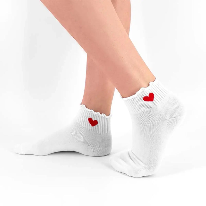 Chaussettes basses unies volantées. Cœur rouge discret, coton doux, noir ou blanc. Confortables, féminines et idéales pour la mi-saison.