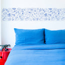 Décoration murale au-dessus d’un lit avec le motif dinosaures du rouleau adhésif OMY