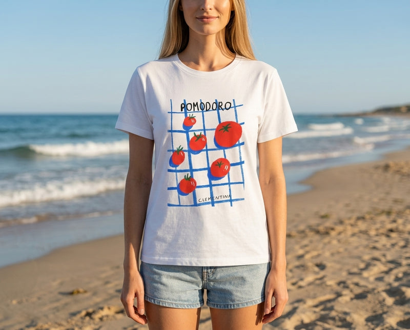 Clementina Italy Pomodoro T-shirt on beach. Relaxed Mediterranean vibe.