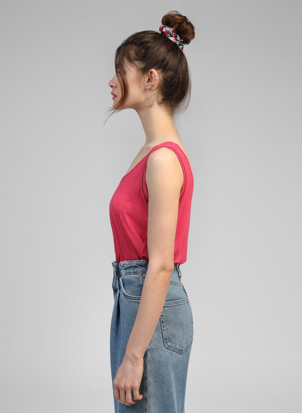 An'ge – Debardeur Tanessa Framboise, mannequin de profil portant un débardeur rose et un jean bleu