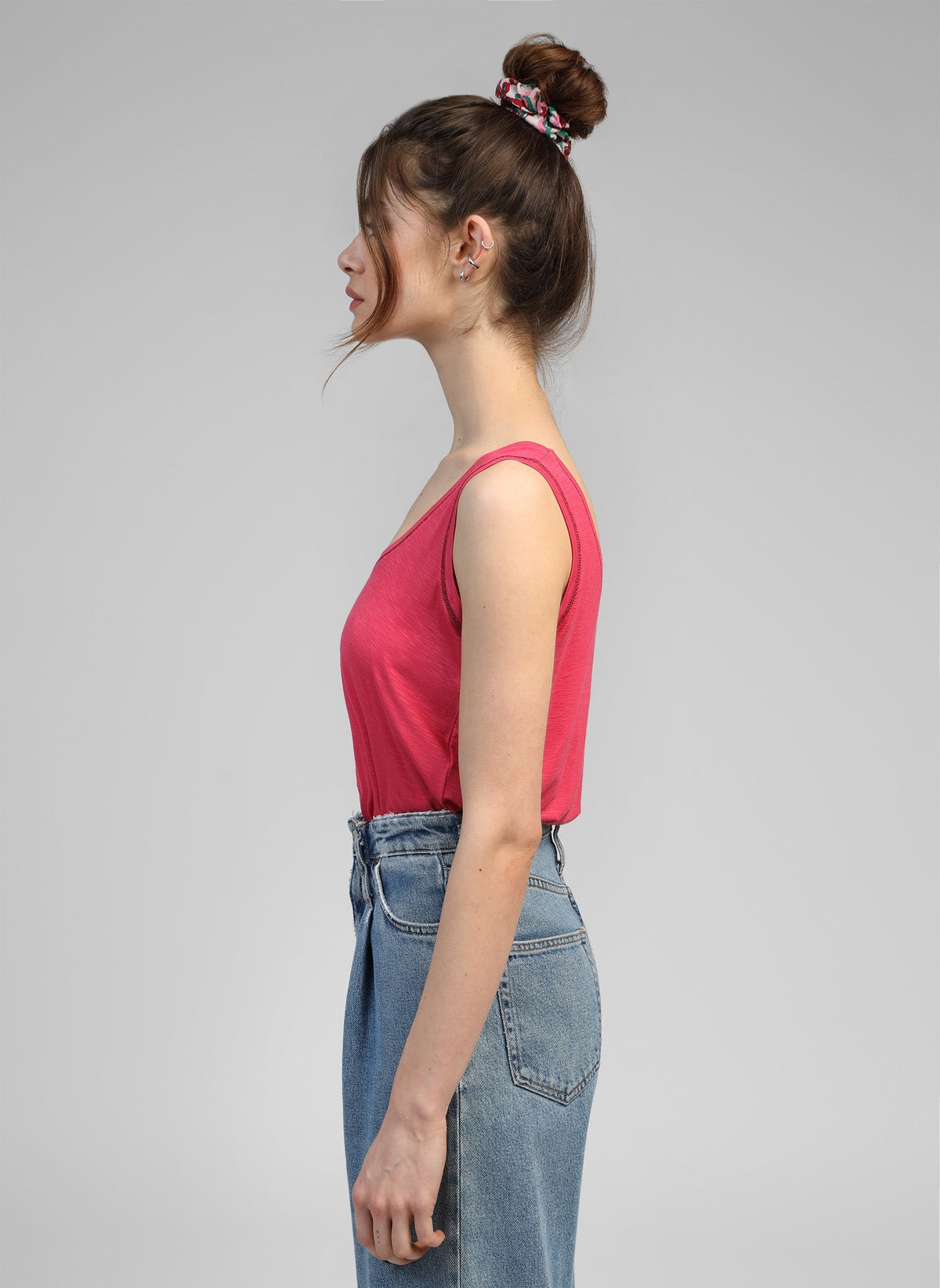 An'ge – Debardeur Tanessa Framboise, mannequin de profil portant un débardeur rose et un jean bleu