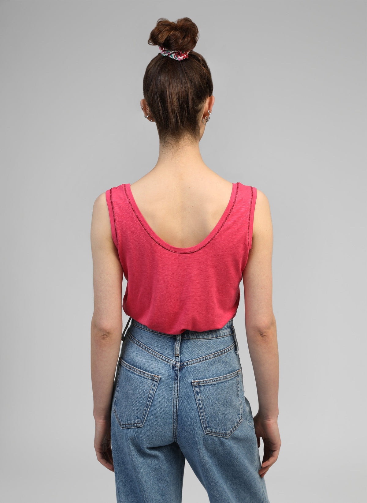An'ge – Debardeur Tanessa Framboise, mannequin de dos portant un débardeur rose et un jean bleu