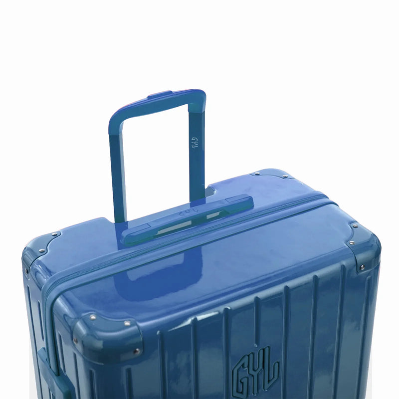 Poignée trolley télescopique GYL déployée sur la valise Intemporelle bleu grisé en polycarbonate. #couleur_bleu grisé