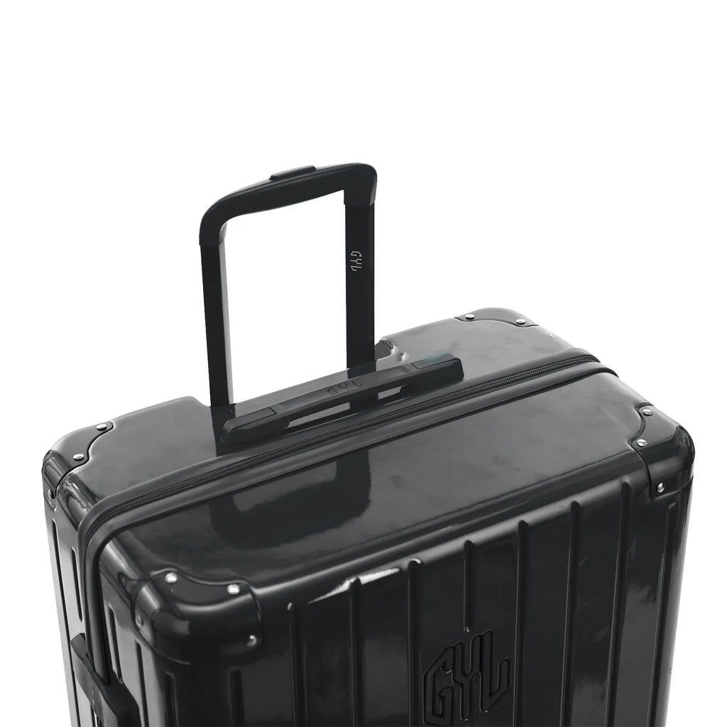 Poignée trolley télescopique GYL déployée sur la valise Intemporelle gris foncé en polycarbonate. #couleur_gris foncé