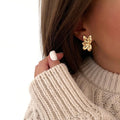 Instants Plaisirs – Boucles D'Oreilles Minia - Acier, boucles d'oreilles dorées portées par une femme, vue de profil