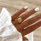 Instants Plaisirs – Bague Fei - Acier, bague dorée portée sur une main, vue de dessus, ongles blancs