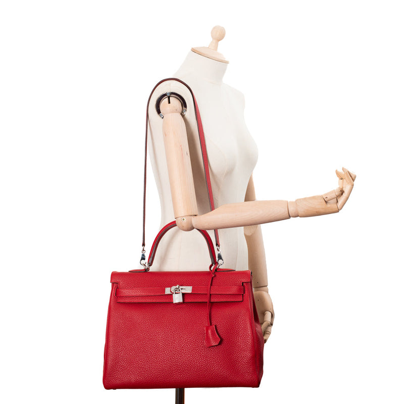 sac de seconde main kelly hermès  en cuir rouge  porté 1